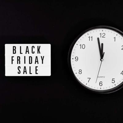 a black friday sale signage beside a black and white round analog wall clock