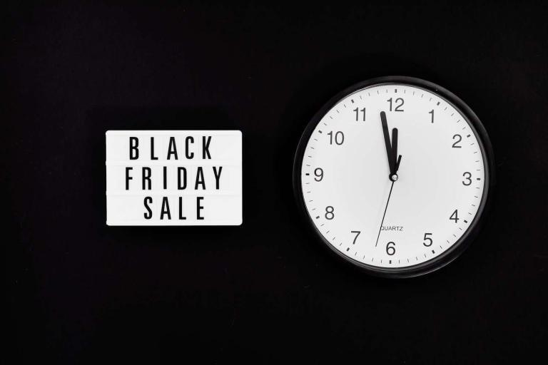 a black friday sale signage beside a black and white round analog wall clock